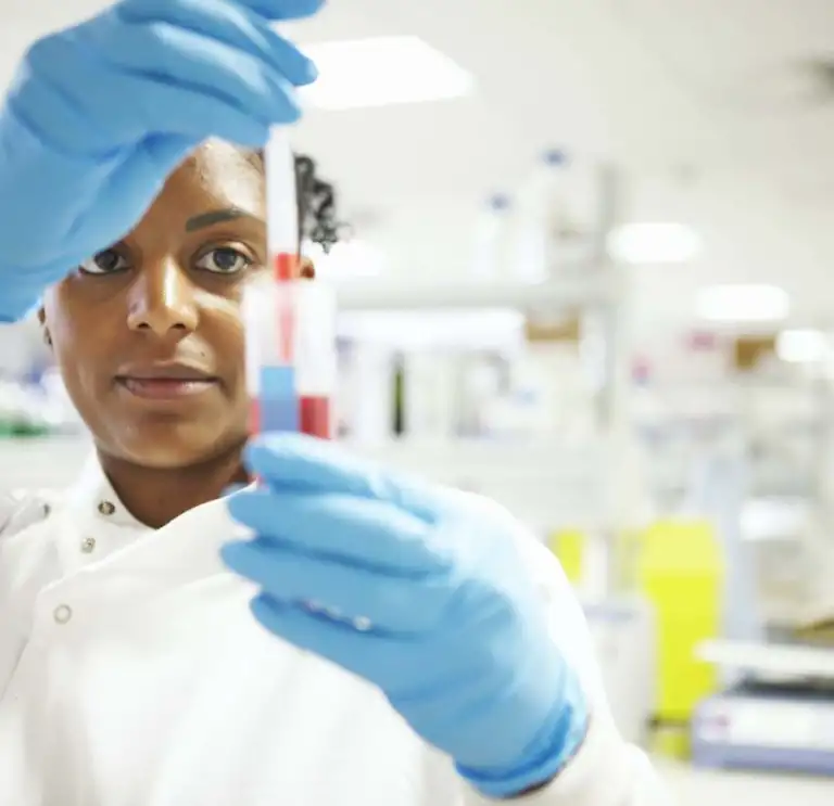 Student measuring liquid in test tube in high-tech lab